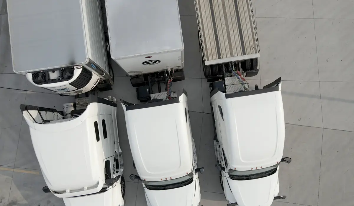three white cargo trucks from a truck logistics company